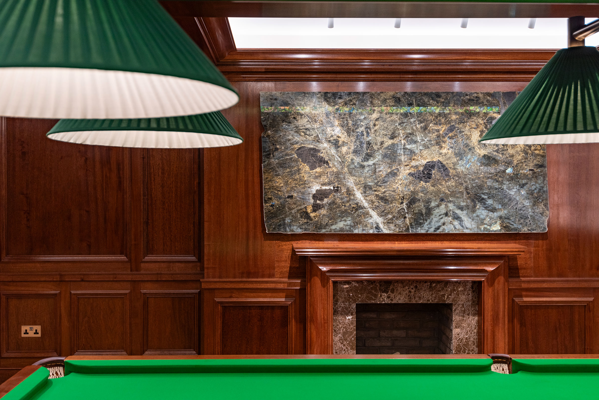 Traditional panelling and matching fireplace with Bolection moulding in african mahoghany for an entertainment soace and gamnes room in a London home by William Garvey Bespoke furniture maker and designer