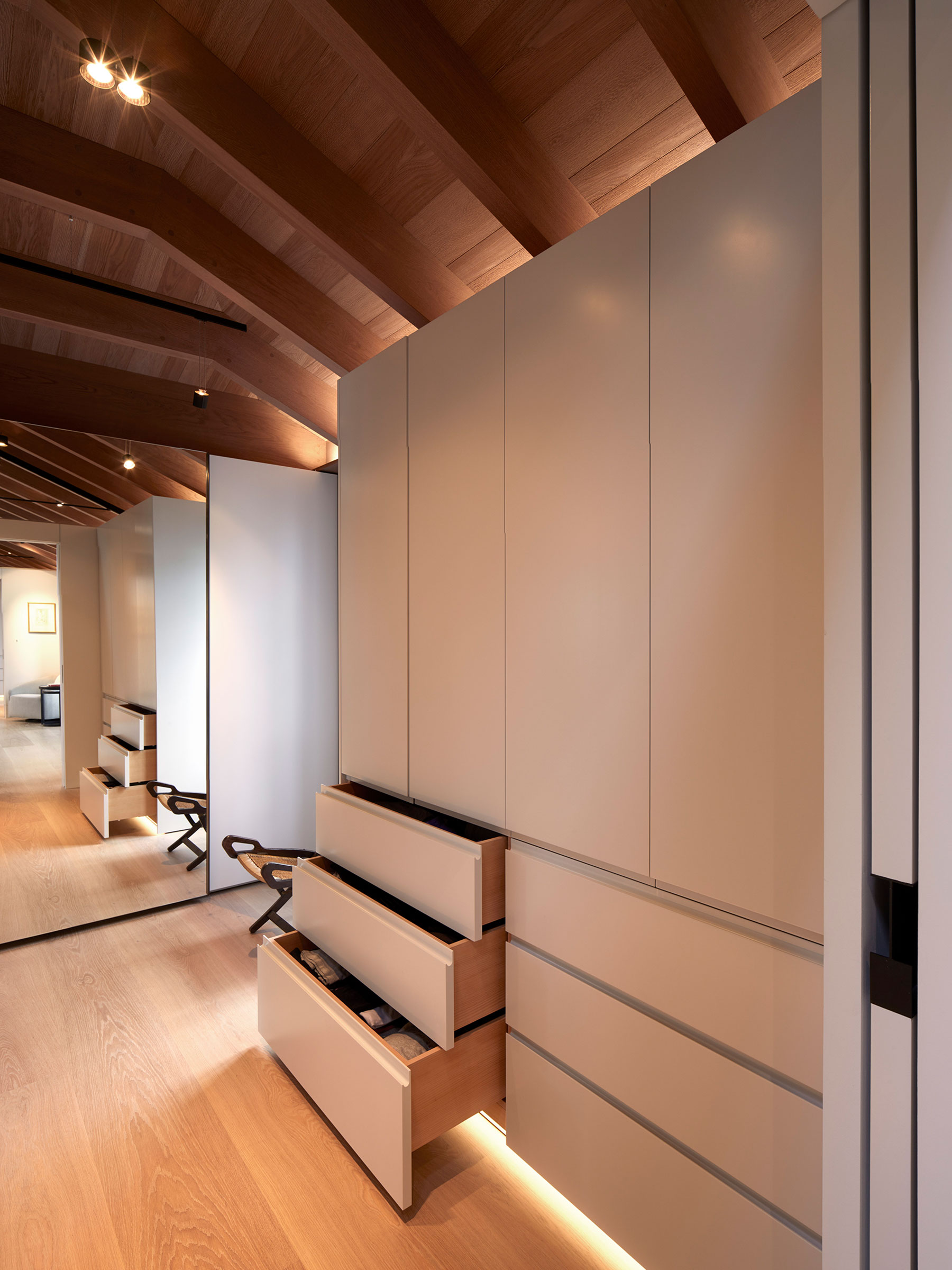 White lacquer handless wardrobes in the walk-in dressing rooms. Our bespoke cabinetry extended throughout the entirety of this Notting Hill mews property. William Garvey bespoke furniture and cabinet maker