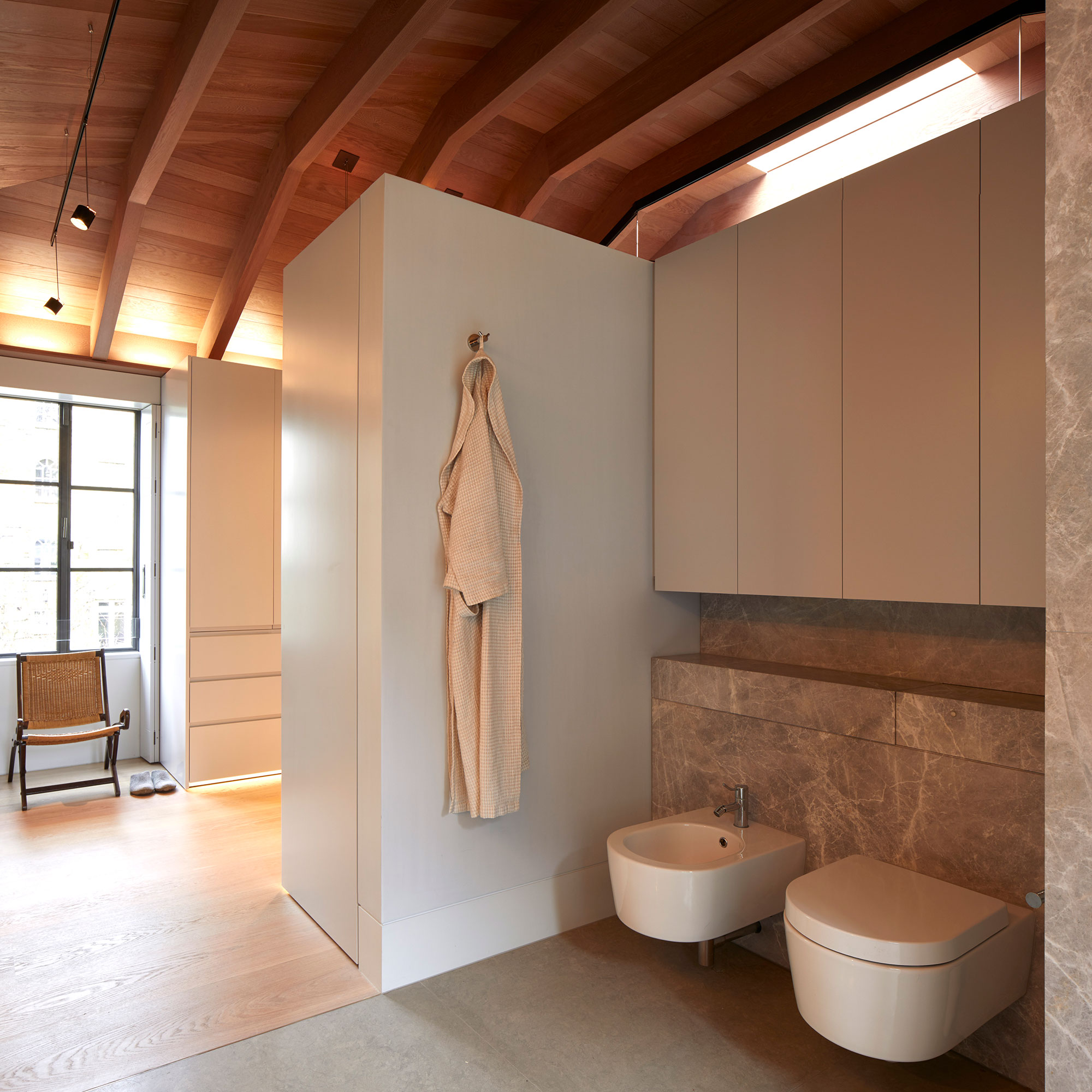 White lacquer handless wardrobes in the walk-in dressing rooms and storage in the bathrooms. Our bespoke cabinetry extended throughout the entirety of this Notting Hill mews property. William Garvey bespoke furniture and cabinet maker