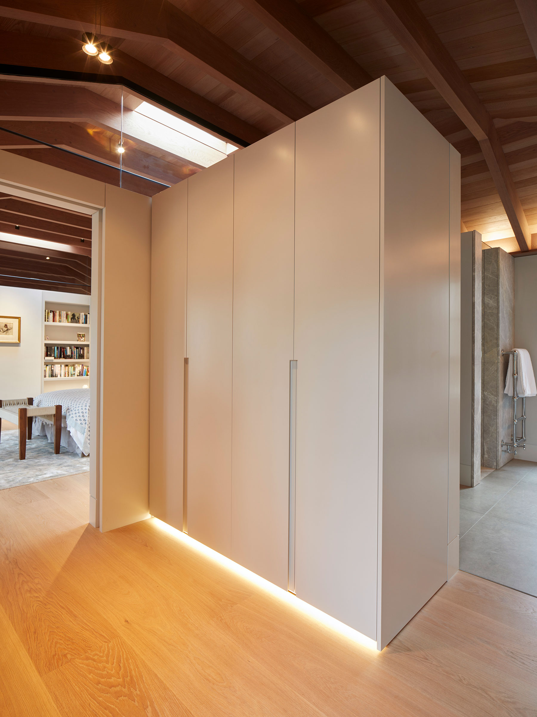 White lacquer handless wardrobes in the walk-in dressing rooms. Our bespoke cabinetry extended throughout the entirety of this Notting Hill mews property. William Garvey bespoke furniture and cabinet maker