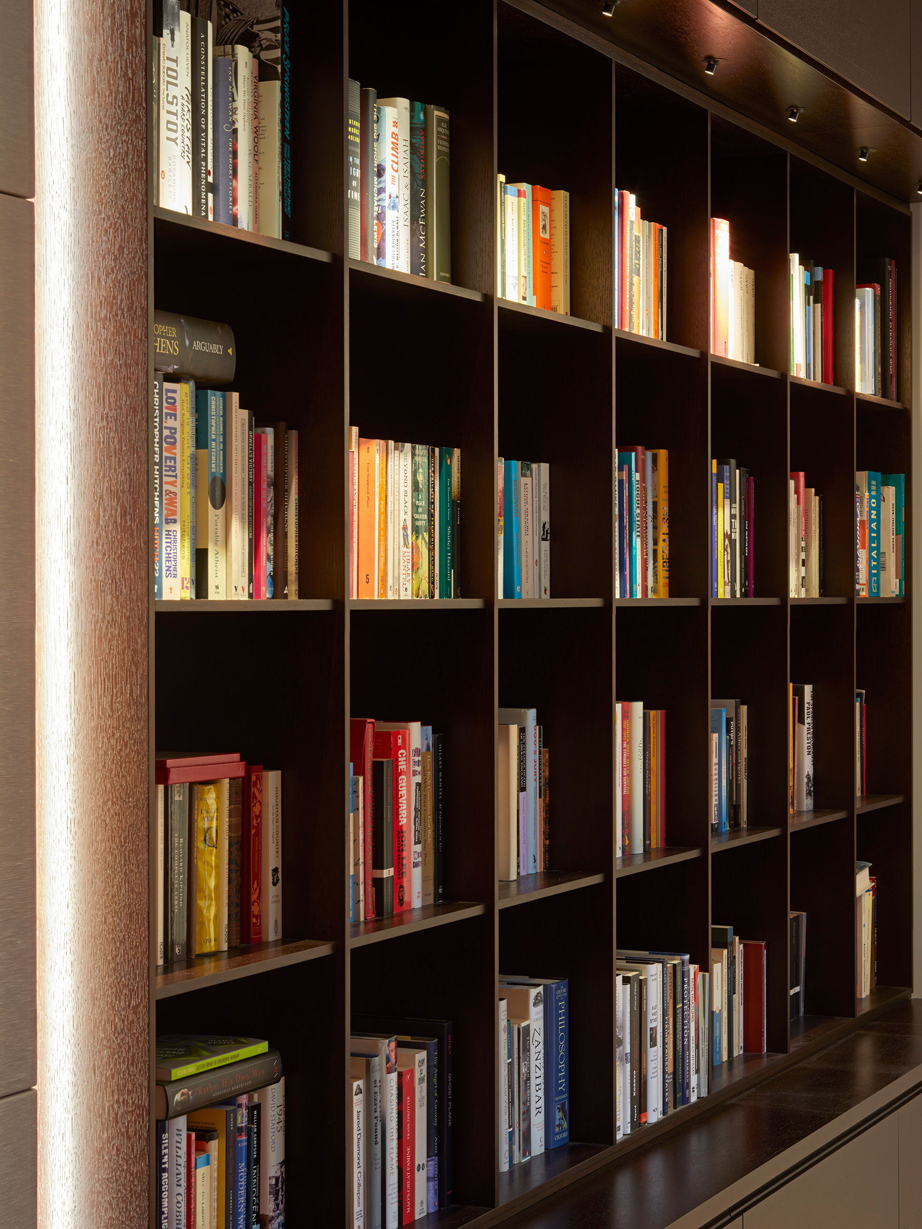 Dark timber shelving as part of the AV media wall unit. Our bespoke cabinetry extended throughout the entirety of this Notting Hill mews property. William Garvey bespoke furniture and cabinet maker