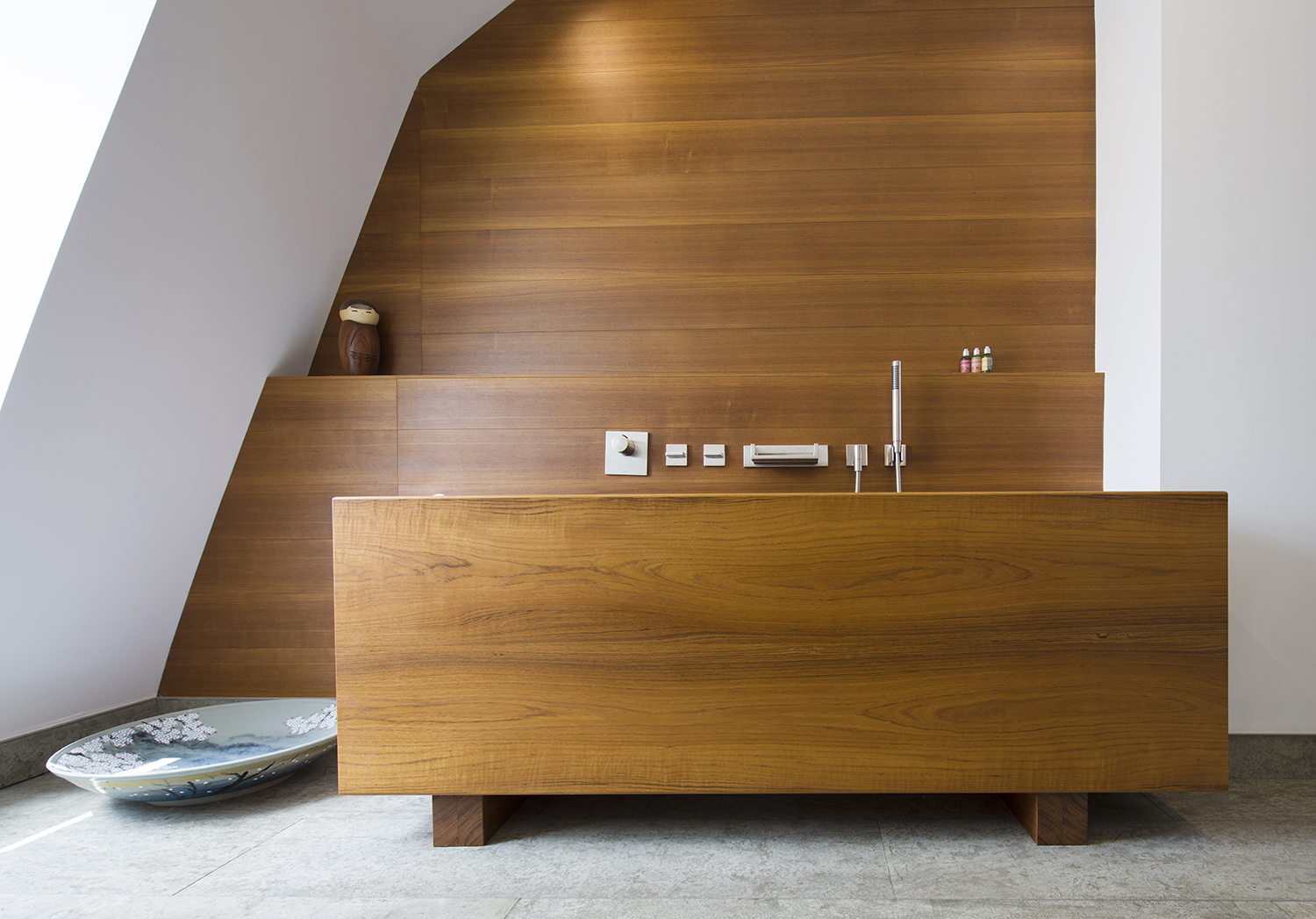 Bespoke waterproof teak bath and teak wall panels in the guest bathroom of a penthouse in bath all by William Garvey furniture designers and makers England