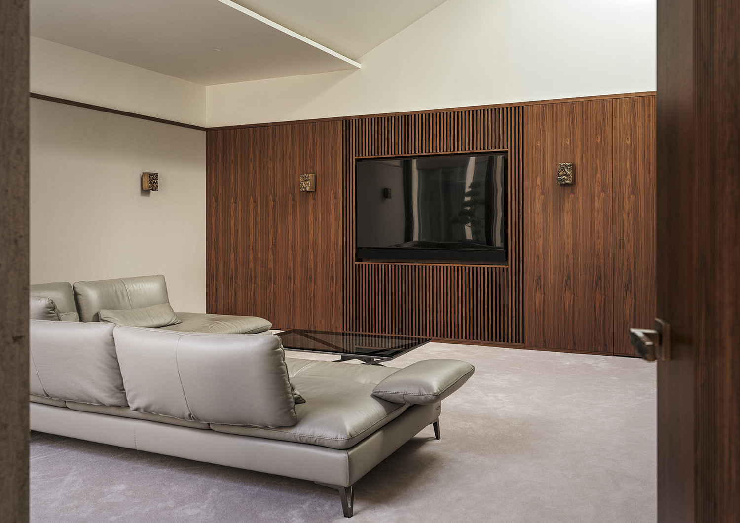 Bespoke flamed walnut wall panelling in the media room of a listed manor house in Somerset - all bespoke joinery and furniture by William Garvey British furniture designers and makers